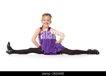 TA-daa. Ganzkörperaufnahme eines jungen Mädchens, das die Splits isoliert auf Weiß macht. Stockfoto