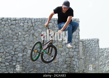 Gehen Sie groß oder Geh nach Hause. Ein BMX-Fahrer macht Tricks in der Stadt. Stockfoto