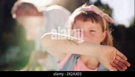 Schauen Sie sich an, was ich gefunden habe. Aufnahme eines jungen Mädchens, das in ihrem Hinterhof Ungeziefer entdeckte. Stockfoto