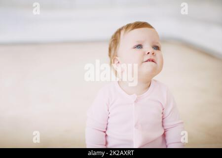 Bitte holt mich ab, Mama. Ein kleines Mädchen, das auf dem Boden sitzt und aussieht wie shes, das darum bittet, abgeholt zu werden. Stockfoto