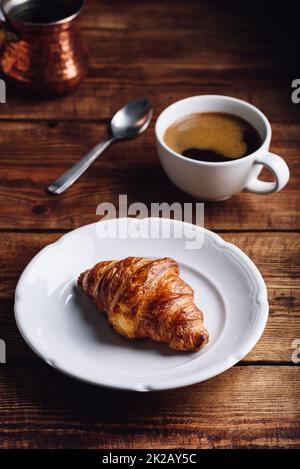 Croissant auf weißem Teller und eine Tasse türkischen Kaffee Stockfoto