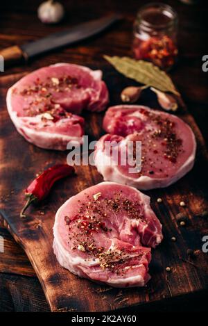 Raw Schweinelende Steaks mit verschiedenen Gewürzen Stockfoto