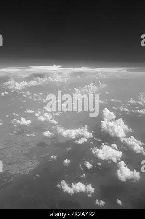Fliegen Sie über Wolken über die Landschaft Thailands in Schwarz und Weiß. Stockfoto