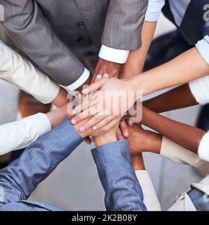 Go, Go Power Business. Ausgeschnittene Aufnahme einer Gruppe von Geschäftsleuten, die in einem Geheule mit angehäuften Händen stehen. Stockfoto