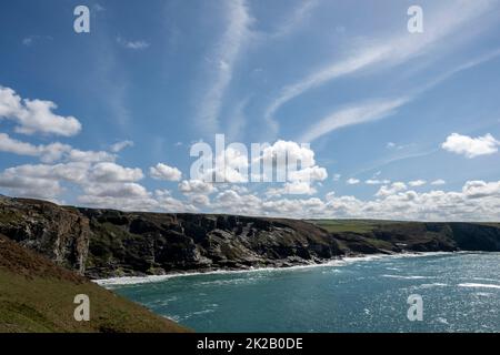 Cirrus und Cumulus Wolken über Trebarwith Klippen vom South West Coast Pfad an einem sonnigen Sommertag. Stockfoto