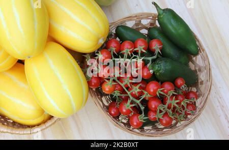 Gemüseernte im Sommer - Ginkaku Koreanische Melonen mit Jalapeno-Paprika und Tomaten Stockfoto