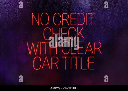 Neonzeichen Keine Kreditprüfung mit Klarer Fahrzeugtitel in regnerischem Fenster Stockfoto