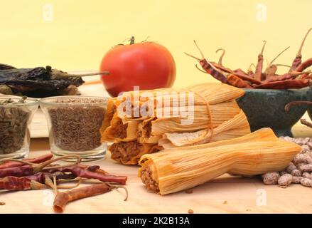 Tamales mit Knoblauch, Bohnen und Tomate auf gelbem Hintergrund Stockfoto