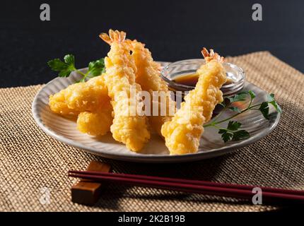 Shrimp Tempura auf einem Teller vor schwarzem Hintergrund. Stockfoto