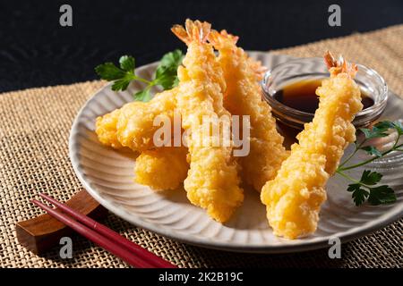 Shrimp Tempura auf einem Teller vor schwarzem Hintergrund. Stockfoto