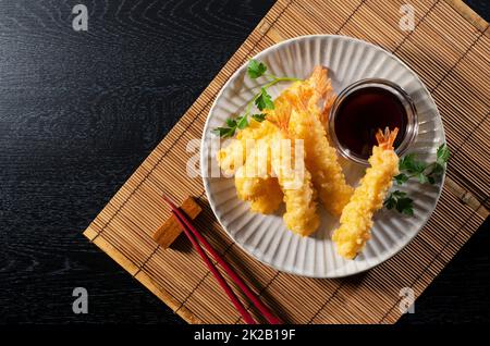 Shrimp Tempura auf einem Teller vor schwarzem Hintergrund. Stockfoto