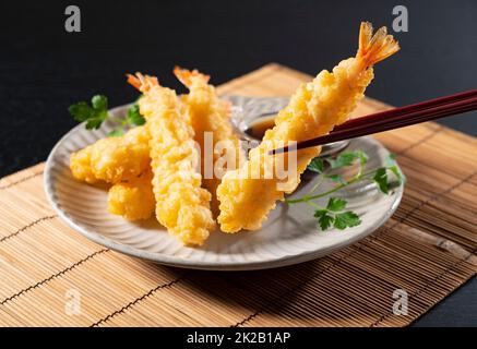 Shrimp Tempura auf einem Teller vor schwarzem Hintergrund. Stockfoto