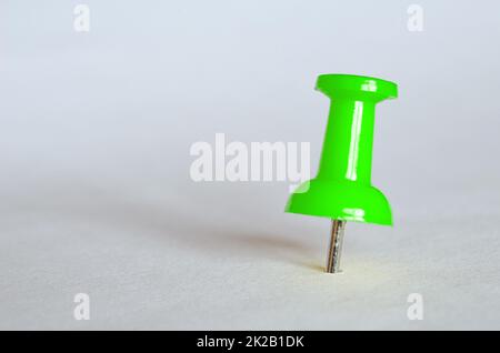 Grüner Druckstift. Nahaufnahme von grünem Daumenhaken Stockfoto