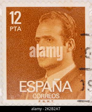 Foto einer orangefarbenen spanischen Briefmarke mit 12 Peseten und einem Bild von König Juan Carlos I. Stockfoto