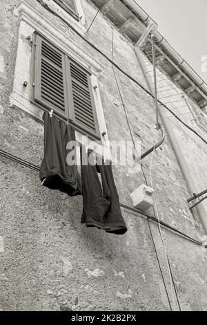 Wäscheleine mit Hose an einer Fassade in der Altstadt von Krk in Kroatien Stockfoto