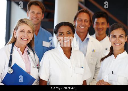 Wir liefern immer wieder. Eine Aufnahme einer Gruppe von Medizinern, die die Kamera anlächeln. Stockfoto