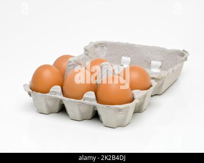 Verpackt voller Protein. Studioaufnahme von einem halben Dutzend braunen Eiern in einem Karton. Stockfoto