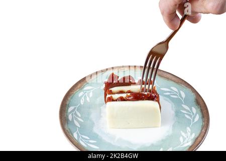 Mann, der mit einer Gabel aufhob, auf einem Guava-süßen und Quark-weißen Hintergrund gestapelt wurde. Stockfoto