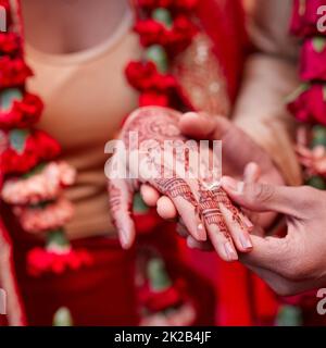 Dieser Ring ist ein Zeichen meiner Liebe. Ausgeschnittene Aufnahme eines hindu-Paares, das am Hochzeitstag Ringe austauscht. Stockfoto