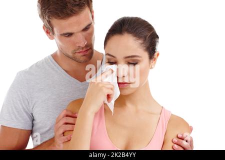 Unterstützung, wenn sie sie am meisten brauchte. Ausgeschnittene Aufnahme eines besorgten Freundes, der seine Freundin tröstet, während er in einem Studio-isoliert auf Weiß steht. Stockfoto