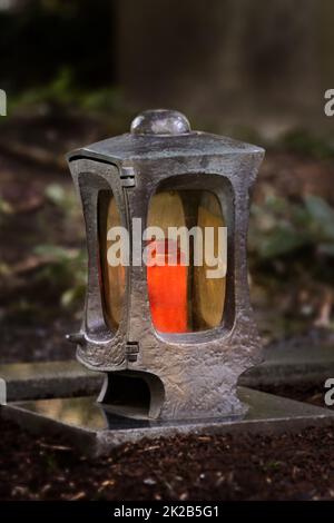 Trauerlaterne auf einem Friedhof in der Abenddämmerung mit brennender Kerze Stockfoto