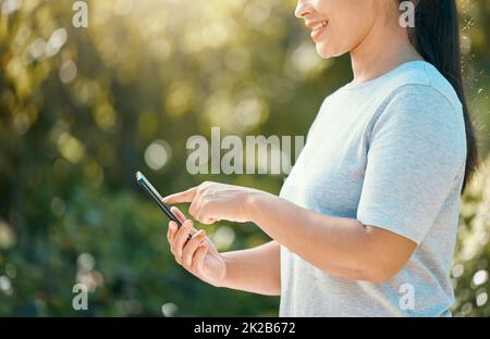 Frau, Telefon und Naturpark, während Sie den Bildschirm für mobile App, Kommunikation für Nachhaltigkeit und Umweltmanagement berühren. Hand des Weibchens Stockfoto