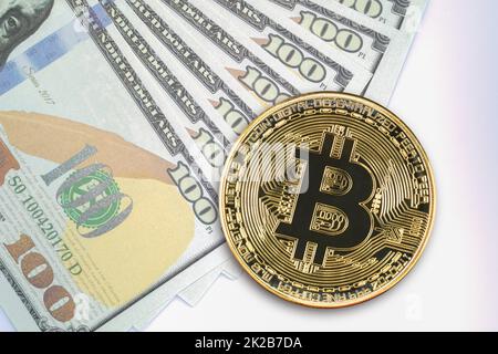 Bitcoin-Münzen und US-Banknoten in Höhe von hundert Dollar Stockfoto