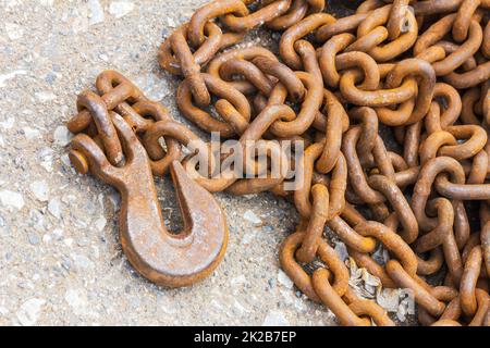 Rostige Haken und Kette auf dem Boden Stockfoto