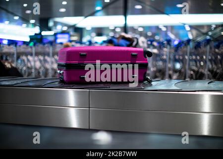 Gepäck ankam, um das Gehen auf einem Förderband wartet an der Gepäckausgabe Zone in einer modernen internationalen Flughafen zu sein behauptet Stockfoto