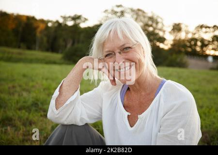 Dem ganzen zu entfliehen. Porträt einer attraktiven reifen Frau, die sich in der Natur entspannt. Stockfoto