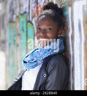 Bereit für ihre Zukunft. Porträt einer schönen jungen Frau, die sich in der Stadt an einer Mauer lehnt. Stockfoto