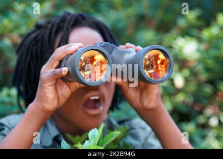 Die Natur ist UNGLAUBLICH. Ein kleiner Junge schaut durch sein Fernglas. Stockfoto