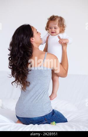 Mein wunderschöner kleiner Engel. Rückansicht einer Mutter, die ihre kleine Tochter hochhält. Stockfoto