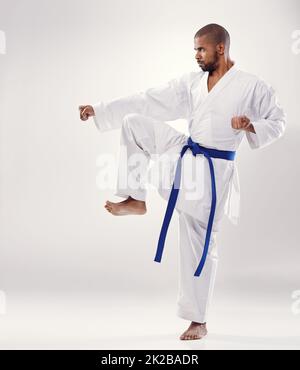 Perfekte Form. Ein afrikanischer Mann, der Karate macht. Stockfoto