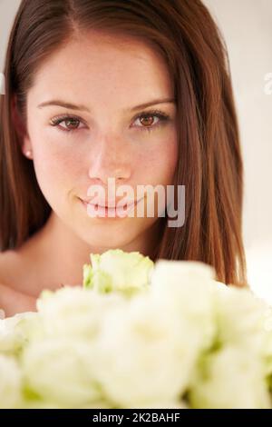 Shes die schönste von allen. Porträt einer schönen jungen Frau, die lächelt und einen Blumenstrauß hält. Stockfoto