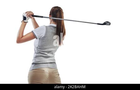 Perfektioniert ihre Durchfolge. Studioaufnahme einer jungen Golferin, die ihren Schwung isoliert auf Weiß übt. Stockfoto