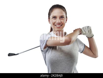 Mit ihrem Verein selbstbewusst umgehen. Studioaufnahme einer jungen Golferin, die ihren Schwung isoliert auf Weiß übt. Stockfoto