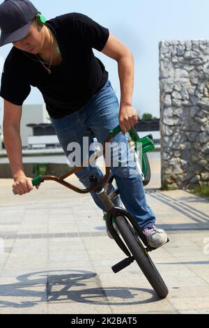 Ein Showstopping-Trick. Ein BMX-Fahrer macht Tricks in der Stadt. Stockfoto