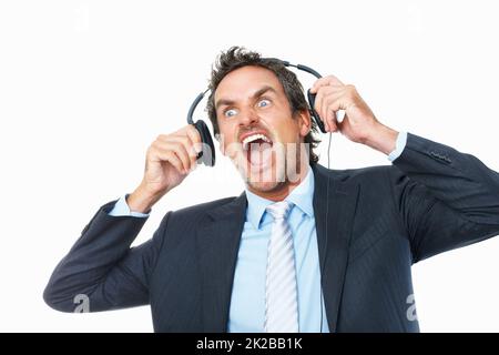 Geschäftsmann schockiert von lauter Musik auf Kopfhörern. Schockiert reifer Geschäftsmann Entfernen Kopfhörer vor weißem Hintergrund. Stockfoto