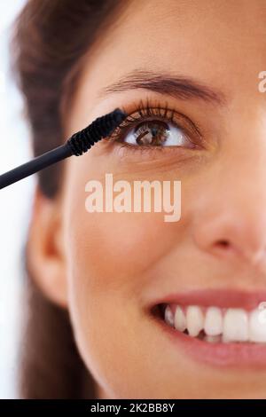 Lash Love. Aufnahme einer schönen jungen Frau, die Mascara auf ihre Wimpern aufgibt. Stockfoto