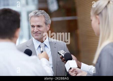 Haben Sie einen Kommentar Sir? Aufnahme eines reifen Geschäftsmannes, der von Reportern interviewt wurde. Stockfoto