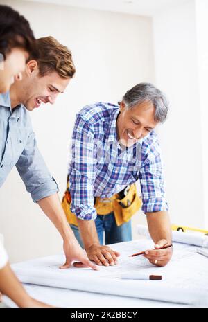 Paar besprechen den Renovierungsplan mit dem Architekten. Glückliches junges Paar, das sich mit dem Ingenieur einen Entwurf ansah, während es über die Renovierung des Hauses sprach. Stockfoto