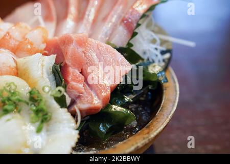 Das Sashimi-Set ist wunderschön in einem Holzteller angeordnet. Buffet Mit Japanischer Küche. Nach Wahl des Küchenchefs: Thunfisch, Engawa, Garnelen und Hamachi Stockfoto