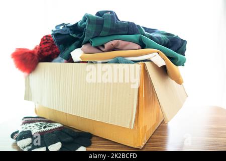 Spendenbox mit gebrauchter Kleidung zu Hause, um die Hilfe für arme Menschen in der Welt zu unterstützen. Stockfoto