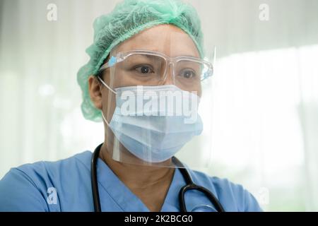 Asiatischer Arzt mit Gesichtsschutz und PSA entsprechen der neuen Norm zur Kontrolle der Patientensicherheit Infektion Covid 19 Coronavirus Ausbruch auf Quarantäne Krankenstation Krankenpflege. Stockfoto