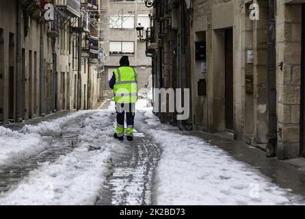 Ein Mann, der verschneite Straßen putzt Stockfoto
