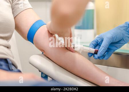 Nahaufnahme eines Arztes, der die Blutprobe aus dem Arm des Patienten im Krankenhaus für medizinische Tests entnehmen kann. Stockfoto