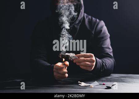 Drogenabhängiger oder Drogendealer bereitet Heroin zu. Stockfoto