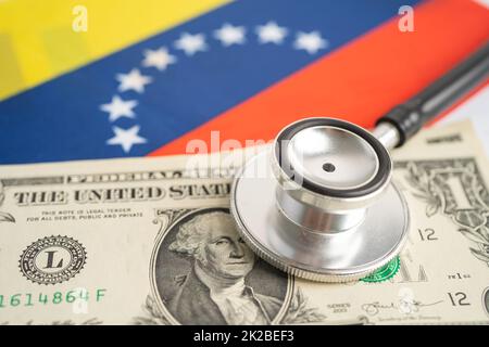 Schwarzes Stethoskop mit US-Dollar-Banknoten auf Hintergrund der venezolanischen Flagge, Geschäfts- und Finanzkonzept. Stockfoto