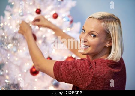 Es muss perfekt sein. Porträt einer jungen Frau, die zu weihnachten über ihre Schulter schaut. Stockfoto